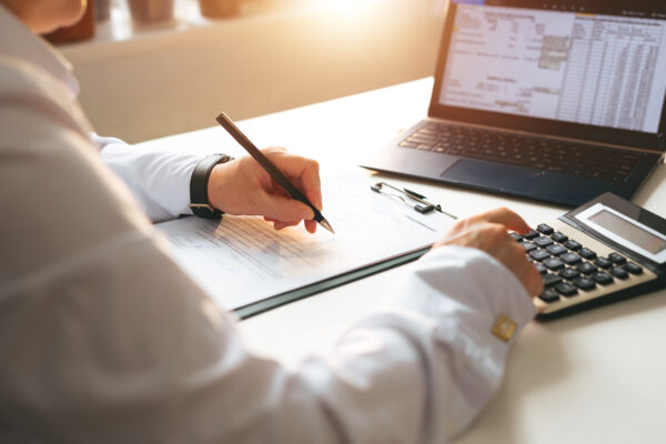 Business owner reviewing tax documents and calculating filings with cloud-based tax software—emphasizing efficient, compliant small business tax services