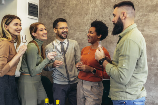 Group of young professionals smiling and clinking glasses at a networking event, symbolizing growth and recognition. Image used to highlight The William Stanley CFO Group’s feature by Brian Hartz in The Business Observer.